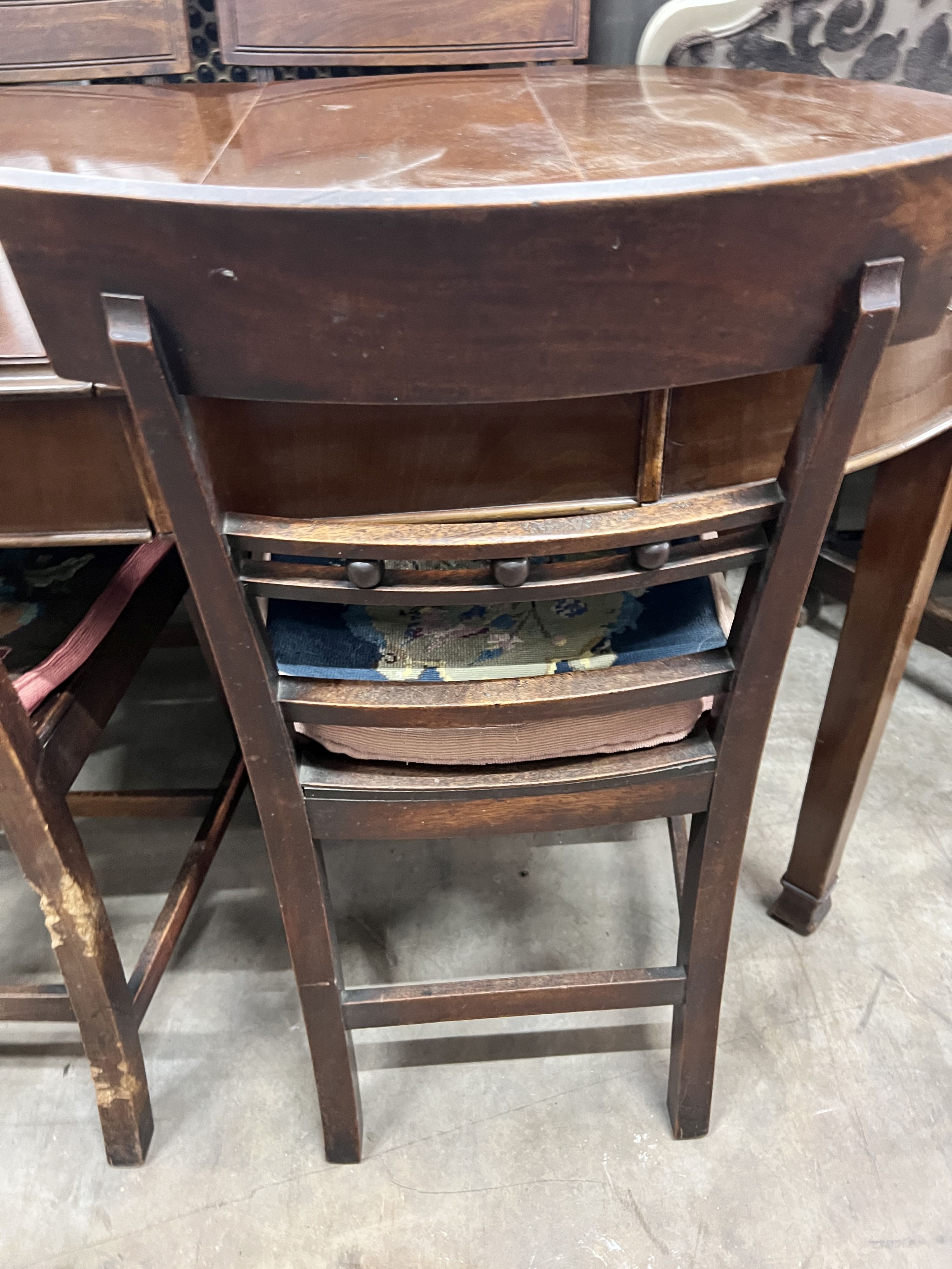 A set of six (4 + 2) Georgian mahogany dining chairs, with solid dished seats, on square tapering legs, gros-panel needlework cushions